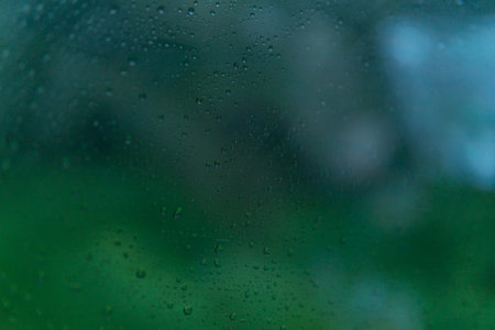 Water drop onâ€‹ glass ofâ€‹ carâ€‹ onâ€‹ theâ€‹ Roadâ€‹ in rainy...