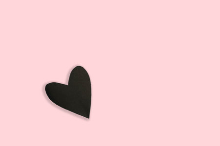Black paper heart on pink background, valentine's day conceptの写真素材