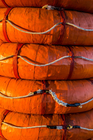 Close up of Orange lifebuoy on a boat in the port.の写真素材