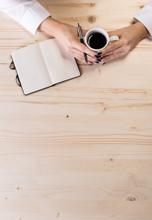 Business woman in an office holding coffe - bird perspectiveの写真素材