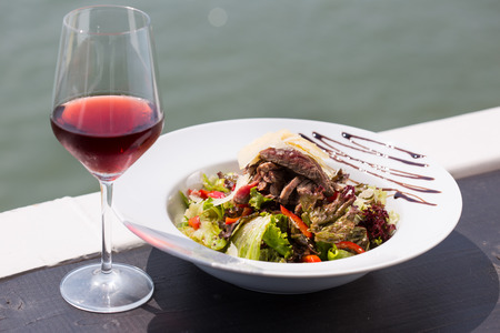 beef salad serve by the river with red wineの写真素材