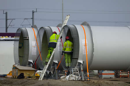 Construction workers preparing the rotor blades of a new wind turbine.の写真素材