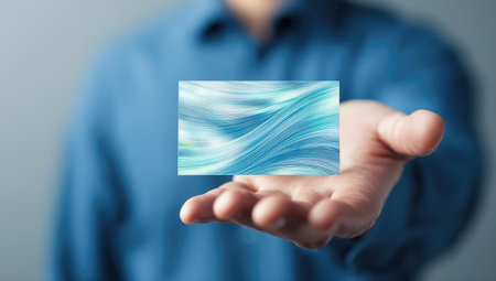 Hand holding a light blue, abstract rectangleの素材