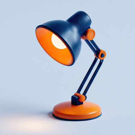 A modern desk lamp is illuminated against a light blue backdrop. The lamp features a black shade and arm, with orange accents. The composition includes a warm, bright glow emanating from the lamp. This image is suitable for advertising, educational content, or website design.の素材