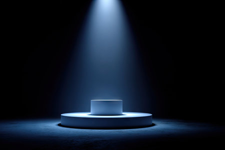 A circular podium stage is illuminated by a single spotlight against a dark background. The image showcases a minimalist design with a focus on the stage's form and the play of light and shadow. The cool color palette and overhead lighting suggest a professional setting suitable for presentations, product displays, and conceptual visuals.の素材