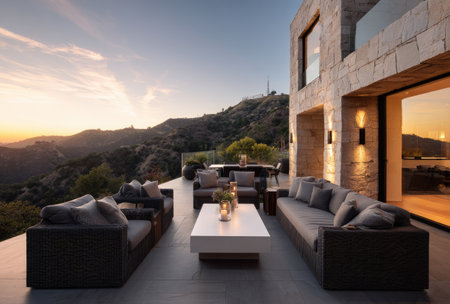 A contemporary outdoor living area features comfortable seating and a stylish coffee table. The composition showcases a neutral color palette with dark furniture against a bright horizon. Soft lighting highlights the seating arrangements while an expansive view of rolling hills sets the context. Suitable for commercial applications.の素材