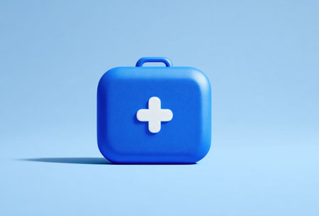 A blue first aid kit with a white cross emblem is presented against a pale blue backdrop. The image features a clean, illustrative style with soft lighting and a minimalist composition. Suitable for healthcare-related content, the visual can be utilized across a range of applications.の素材