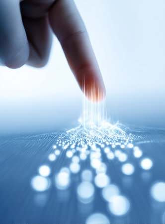 A finger hovers above a glowing cluster of light, suggesting interaction with a digital network. The image presents a cool color palette with a shallow depth of field, creating a futuristic, abstract aesthetic. The composition emphasizes the connection between human and technology, suitable for various editorial and commercial applications.の素材