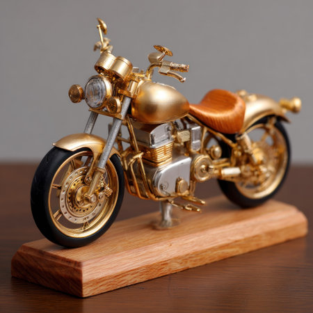 A miniature motorcycle model, primarily gold in color, sits on a wooden base. The design showcases intricate details in metal. The image features strong lighting, enhancing the metallic sheen. This studio shot might be suitable for product showcasing or design concept illustrations.の素材