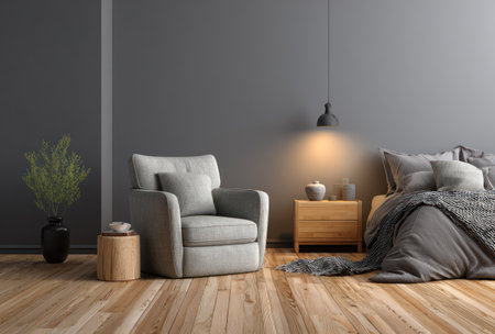 A well-lit, interior scene features a gray armchair and a bedside table. A bed draped with a blanket and pillows is present in the background. The composition includes wooden flooring and dark walls. The image is suitable for various uses, including design projects and illustrative content.の素材