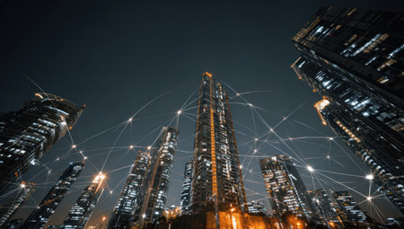 This image showcases a collection of illuminated skyscrapers, viewed from a low angle under a night sky. The scene is dominated by tall buildings with lights, and visual lines representing a network overlaying the cityscape. The composition features a symmetrical arrangement, offering potential use for architectural, technology, and commercial projects.の素材