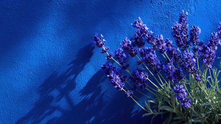 This close-up showcases lavender flowers against a striking blue background with textured details. The composition highlights the flowers' deep purple hue and delicate structure, emphasizing the contrast with the rich blue. Ideal for various projects, this image lends itself well to editorial and commercial applications requiring visual appeal.の素材