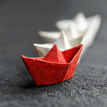 Photo of a red paper boat leading other white boats on a gray background, symbolizing the leader's role in team management and the final depiction for a stock photo. Web banner with copy space on the right side. --chaos 30 --stylize 750 --v 7 Job ID: 211ace2f-4d7a-4bb3-8f72-c984be2869ebの素材