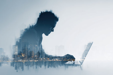 A person is silhouetted, using a laptop. The image incorporates a city skyline overlayed onto the silhouette, with various shades of blue and white. This composition employs a soft, blended style, creating an atmosphere of technology and innovation. Suitable for illustrating ideas related to business, communication, or futuristic themes.の素材