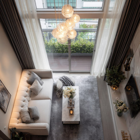 An interior perspective showcases a modern living room design. The space features a white sofa, a marble coffee table, and an area rug, with decorative lighting. Large windows allow ample natural light, and the composition includes elements of green foliage. Suitable for commercial and editorial applications.の素材