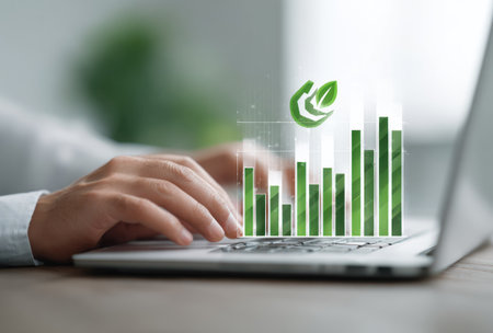 A person is using a laptop computer, with an overlay featuring a green bar graph and a leaf symbol. The composition is close-up, the lighting appears soft, suggesting an indoor setting. This image is suitable for illustrating concepts of growth, technology, and environmental responsibility, potentially for commercial applications.の素材