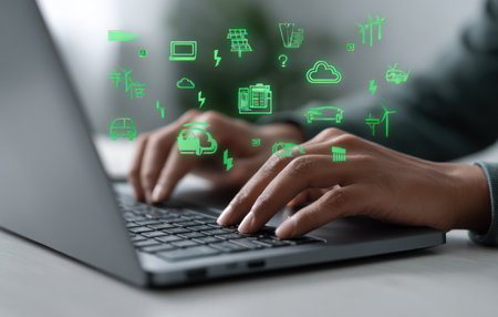 An individual uses a laptop, interacting with digital icons that symbolize various technological concepts. The image showcases a close-up of hands typing on a computer keyboard, with vibrant green graphics floating above. The scene is illuminated with a soft, natural light, implying an indoor setting, suitable for illustrating technology and communication.の素材