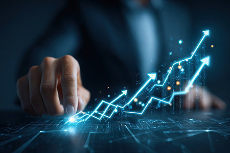 An image shows a hand interacting with a glowing chart, representing financial growth. The composition uses cool blue tones, digital lines, and an upward arrow, suggesting progress. The image may be utilized in commercial contexts for illustrating business development, investment, and market trends, or other financial topics.の素材