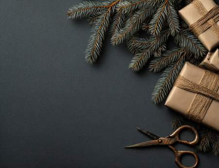 Christmas presents wrapped in brown paper and tied with twine are arranged alongside fir branches and scissors on a dark surface. The composition features overhead lighting and provides copy space. This image could be used in a variety of commercial and editorial projects related to the holiday season.の素材