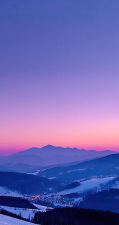 The image features a mountain range under a vibrant, gradient sky of pink and purple hues. The composition showcases layers of mountains in silhouette, suggesting depth. The scene is illuminated by soft, natural lighting, creating a serene and potentially awe-inspiring visual. Suitable for editorial and commercial applications.の素材