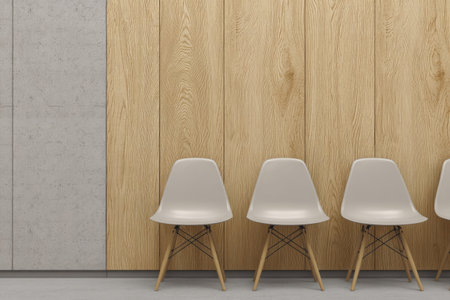 Four white chairs are arranged in a row against a backdrop of light wood paneling. The composition also features a section of concrete wall. The scene is illuminated with even, diffused lighting, suggesting an indoor setting. This image could be suitable for architectural, design, or lifestyle publications.の素材