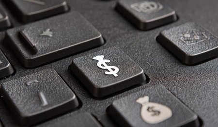 This close-up showcases a keyboard with focus on the dollar sign key. The image displays the texture and color of the keys, lit by available lighting. This image could be used in finance or business articles. It could also apply to software and web design illustrations.の素材