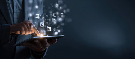 A person is interacting with a tablet, fingers touching the screen. Digital icons float above the device, connected by light trails. The background is a gradient of dark blues. This image could be used for topics related to technology, data analysis, or digital communication. Suitable for various commercial uses.の素材