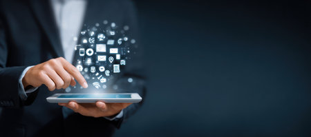 A person in a dark business suit interacts with a tablet, with a collection of digital icons emerging from the device. The composition uses a dark, professional aesthetic, possibly suggesting an office environment. This image is potentially suitable for various commercial purposes, including business, communication, and technological themes.の素材