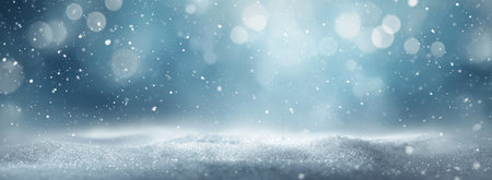 A tranquil winter scene depicts falling snow particles against a softly blurred, blue-toned backdrop with glowing bokeh highlights. The composition suggests an open, expansive environment with a frosted foreground. This imagery could be utilized for various commercial and editorial applications, offering a serene and evocative atmosphere.の素材