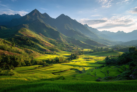A scenic landscape presents majestic mountains and lush green fields. The image features a bright, sunny composition, with deep shadows and varying textures across the terrain. The expansive view suggests a vast natural environment, ideal for diverse commercial and editorial applications.の素材