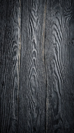 This image presents a close-up of dark wood planks, displaying intricate grain patterns. The texture features shades of black and gray, with visible natural lines and knots. The composition offers a detailed view of the wood's surface, suitable for various uses. It has potential for commercial and editorial purposes.の素材