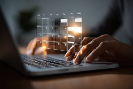 A person's hands interact with a laptop keyboard, featuring a digital calendar overlay. The image highlights a technological interface, with soft lighting and a blurred background. This visual could be used in content related to time management, business, or technology, offering a modern aesthetic suitable for various applications.の素材