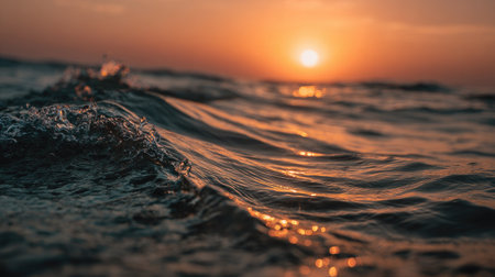 The image showcases ocean waves during a sunset, with warm sunlight illuminating the water. The composition focuses on the textures and movement of the waves. The scene has a natural and serene atmosphere with golden and dark colors. It is suited for various commercial and editorial projects.の素材