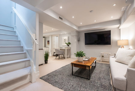 This interior showcases a contemporary living room design. The scene includes a staircase, a sofa, a television, and various decorative elements. The composition features a neutral color palette with soft lighting, suggesting a relaxed atmosphere. This image could be used for various commercial projects related to home decor or interior design.の素材