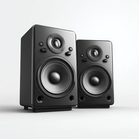 Two black audio speakers are positioned against a bright, neutral backdrop. The speakers exhibit a modern design with circular drivers. The monochromatic color scheme, including subtle lighting, highlights their form. This image is suited for illustrating sound systems or audio-related concepts, suitable for editorial and commercial applications.の素材