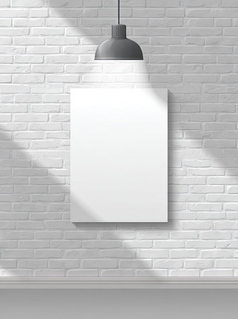 A vertical image displays a blank white canvas suspended against a textured white brick wall. Above, a single overhead light illuminates the canvas, casting shadows. The composition suggests an indoor setting, possibly a studio, with the potential for editorial or commercial applications.の素材