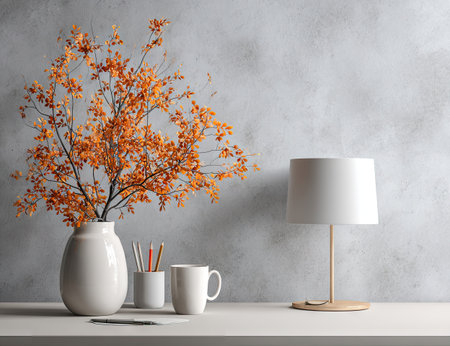 An inviting interior composition displays a vase with vibrant orange foliage, alongside a modern lamp and a cup. The scene is illuminated with soft lighting, highlighting textures. This image can be used for projects related to design, home decor, or conceptual lifestyle themes.の素材