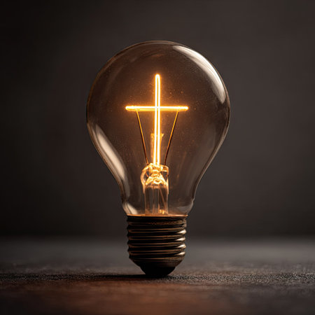 A close-up image presents a glowing lightbulb, with a warm, bright interior. The bulb is positioned against a dark background, suggesting a studio environment. The composition emphasizes the internal illumination, creating a sense of clarity. Ideal for illustrating concepts related to innovation, solutions, or thought.の素材