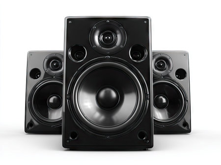 Three black loudspeakers are featured against a clean white backdrop, showcasing a sleek, modern design. The speakers present a symmetrical arrangement, their dark surfaces contrasting sharply with the bright background. The composition suggests a studio or home audio setup, suitable for commercial or editorial applications related to sound and music.の素材