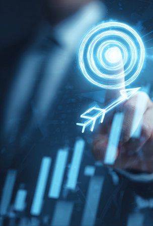 A close-up view depicts a hand touching a glowing digital target. The image features a blue color scheme with a blurred background suggesting data visualization. It incorporates lines and shapes, suggesting a digital or technological context. Suitable for business, finance, or marketing-related visual content, as well as editorial use.の素材