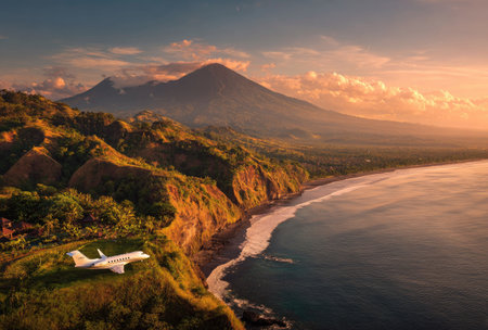 An airplane is seen near a coastline at sunset. The image displays a plane, coast, mountain, and sky with warm colors. The scene highlights nature and aviation, suitable for diverse commercial applications. The composition captures a landscape, possibly used for travel or environmental themes.の素材