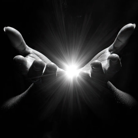 This black and white image features hands reaching upward toward a bright light source. The composition focuses on the hands, highlighting their shape and texture against a dark background. The lighting creates strong contrast and emphasizes the central element, which suggests themes such as hope and guidance. Suitable for various editorial and commercial applications.の素材