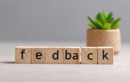 The image features wooden blocks spelling "feedback", positioned near a small plant. The composition is simple, with natural lighting illuminating the objects. This arrangement could be used to illustrate business communication concepts. The presentation is clean, suggesting potential applications in both commercial and editorial contexts.の素材