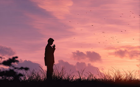 A person stands in silhouette against a vibrant sunset. The composition highlights the figure's outline, framed by grasses and a backdrop of purple and pink clouds. The image suggests tranquility and reflection. Suitable for various editorial and commercial applications promoting themes of contemplation or serenity.の素材
