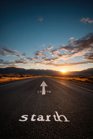 An asphalt road stretches toward the horizon, marked by a painted arrow and the word start. The composition features a vibrant sky filled with clouds, and the scene is illuminated by the warm light of the setting sun. Suitable for concepts of beginning, journey, or progress and could be used in various commercial applications.の素材