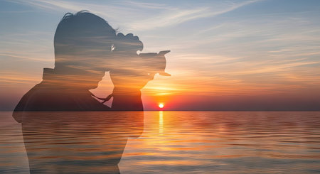 A silhouette of a person holding a camera is superimposed over a scenic sunset. The composition showcases the warm hues of the setting sun reflected on the water's surface, creating a dreamy atmosphere. The image is composed with natural lighting and may be suitable for various editorial and commercial purposes.の素材