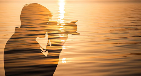 A silhouette depicts a photographer holding a camera, superimposed on a water scene reflecting warm sunset colors. The composition is primarily golden and orange, suggesting a time of day with soft lighting. Suitable for artistic projects, websites, or editorial use, this image evokes a sense of reflection and tranquility.の素材
