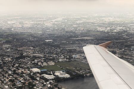 Flight and view over Bangkok in Thailand with nice city panorama from the airplane.の写真素材
