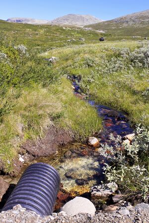 Small red color river by the Vavatn lake. Summer landscape in Hemsedal, Buskerud, Norway.の写真素材