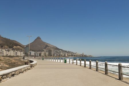 Mountains, hotels and deep blue water with waves at the Sea Point, beach promenade in Cape Town South Africa.の写真素材